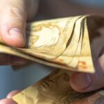 Uma pessoa segurando noras de cinquenta reais