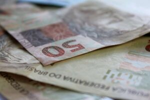 Cédulas de real empilhadas, representando valores financeiros e pagamento de precatórios.