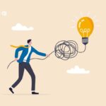 Homem puxando um emaranhado de fios ligado a uma lâmpada acesa.