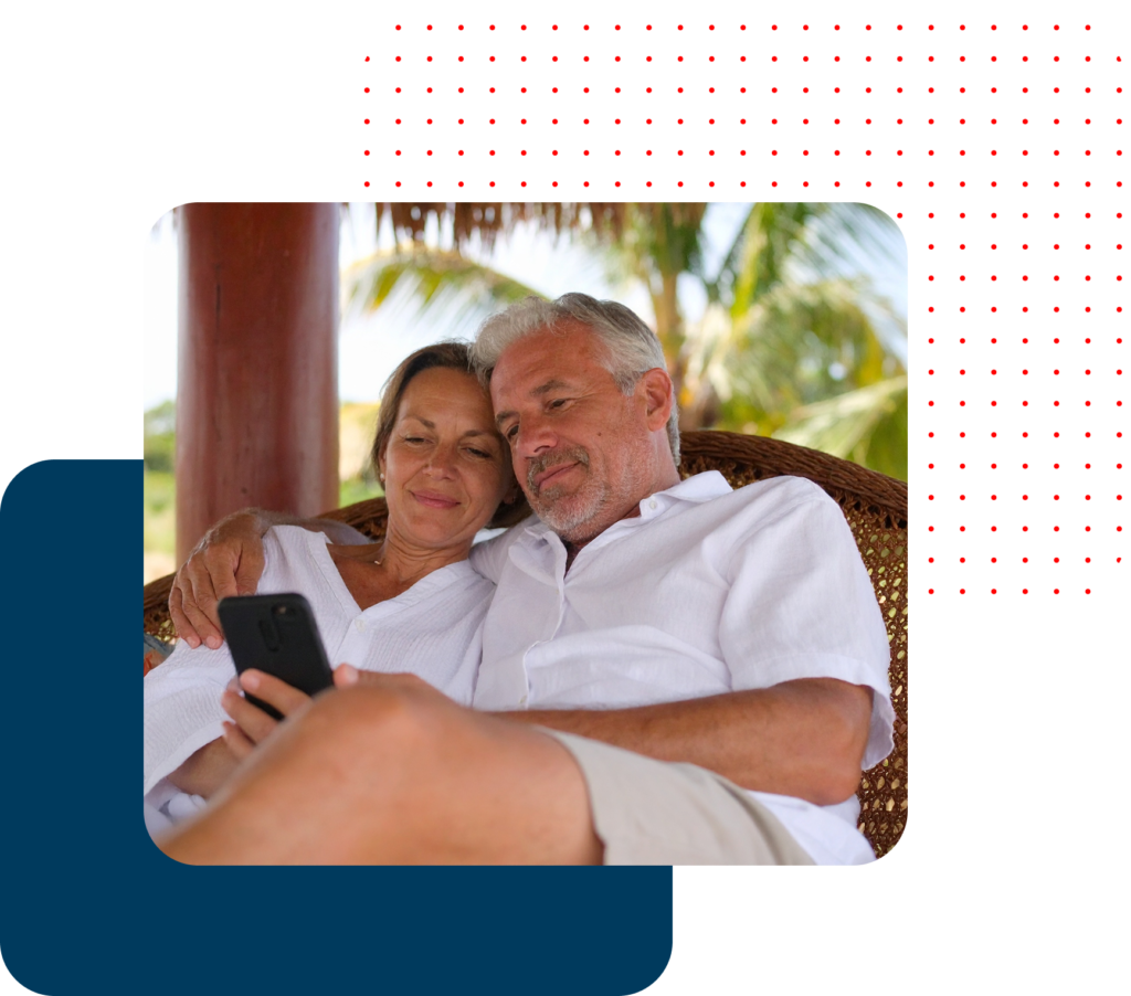 Casal maduro relaxando e olhando um celular em um ambiente tropical.