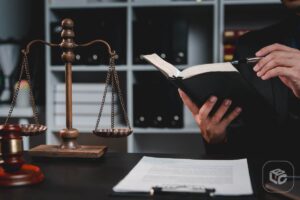Advogado lendo livro com balança da justiça e martelo, para entender adiantamento de RPV.